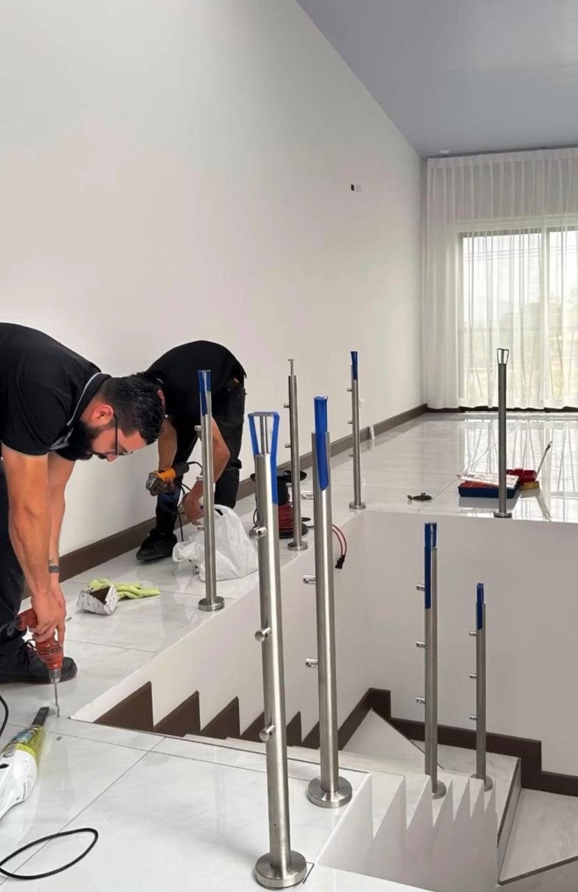 Dos instaladores anclando postes de baranda